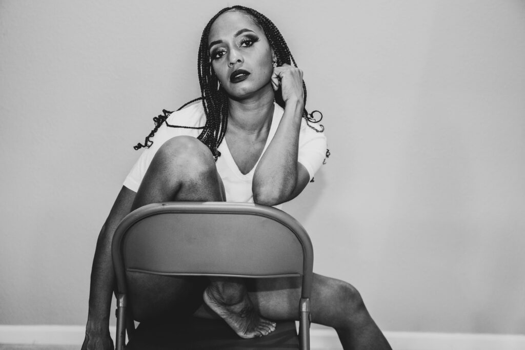 Black Ivy pictured sitting on a chair positioned on the booking page